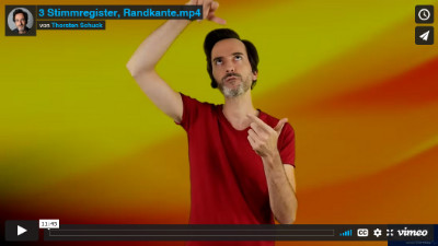 Lektion 3 Online Gesangsunterricht: Thorsten schaut nach oben und zeigt mit einer Hand, wo der Stimmsitz empfunden werden kann.