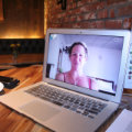 Frau beim Gesangsunterricht online auf Laptop